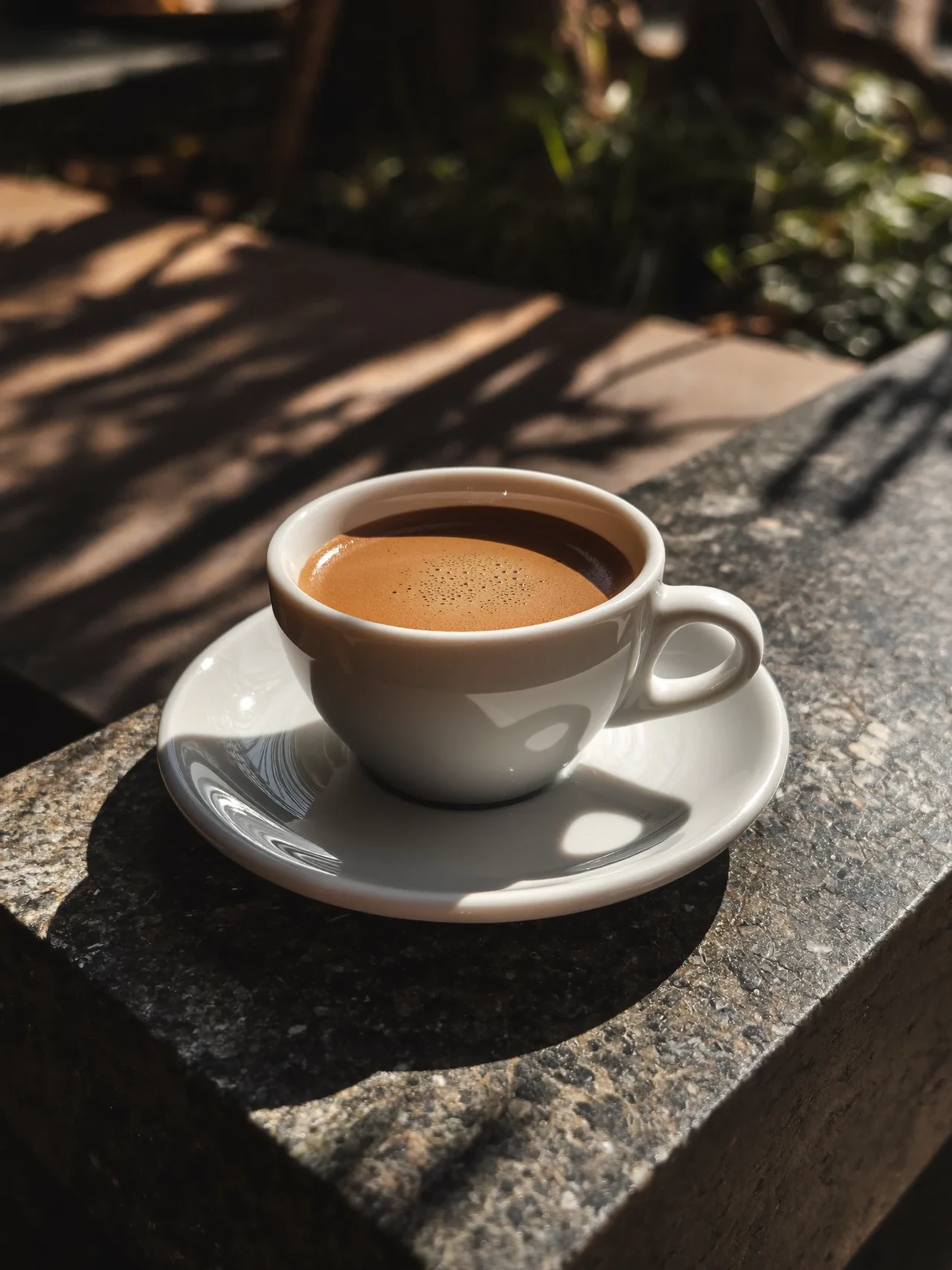 Espresso w białej filiżance na kamiennym blacie, ujęcie z boku