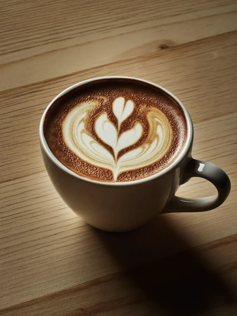 Flat white z latte art w szerokiej filiżance, widok z góry